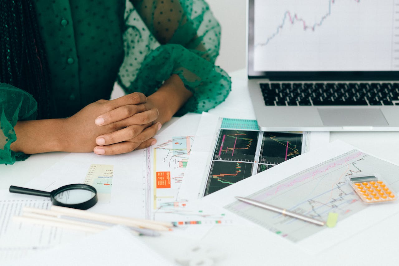 about-01 A person analyzes financial charts and graphs at a desk, indicating business trading activity.